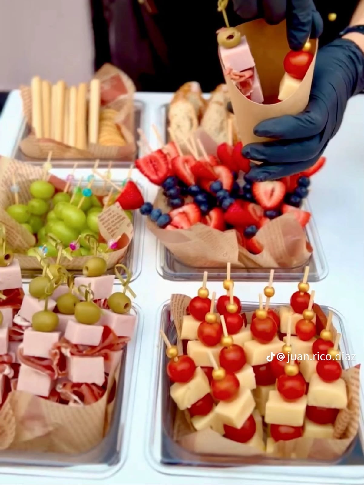 Charcutería con quesos, carnes frías, aceitunas y fruta en porciones individuales